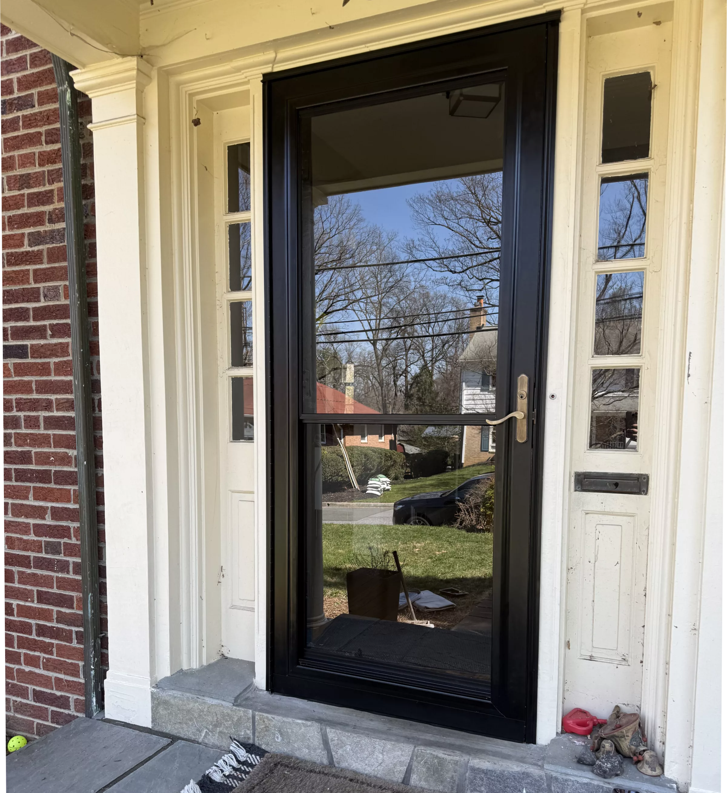 Black storm door installed at residential front entrance