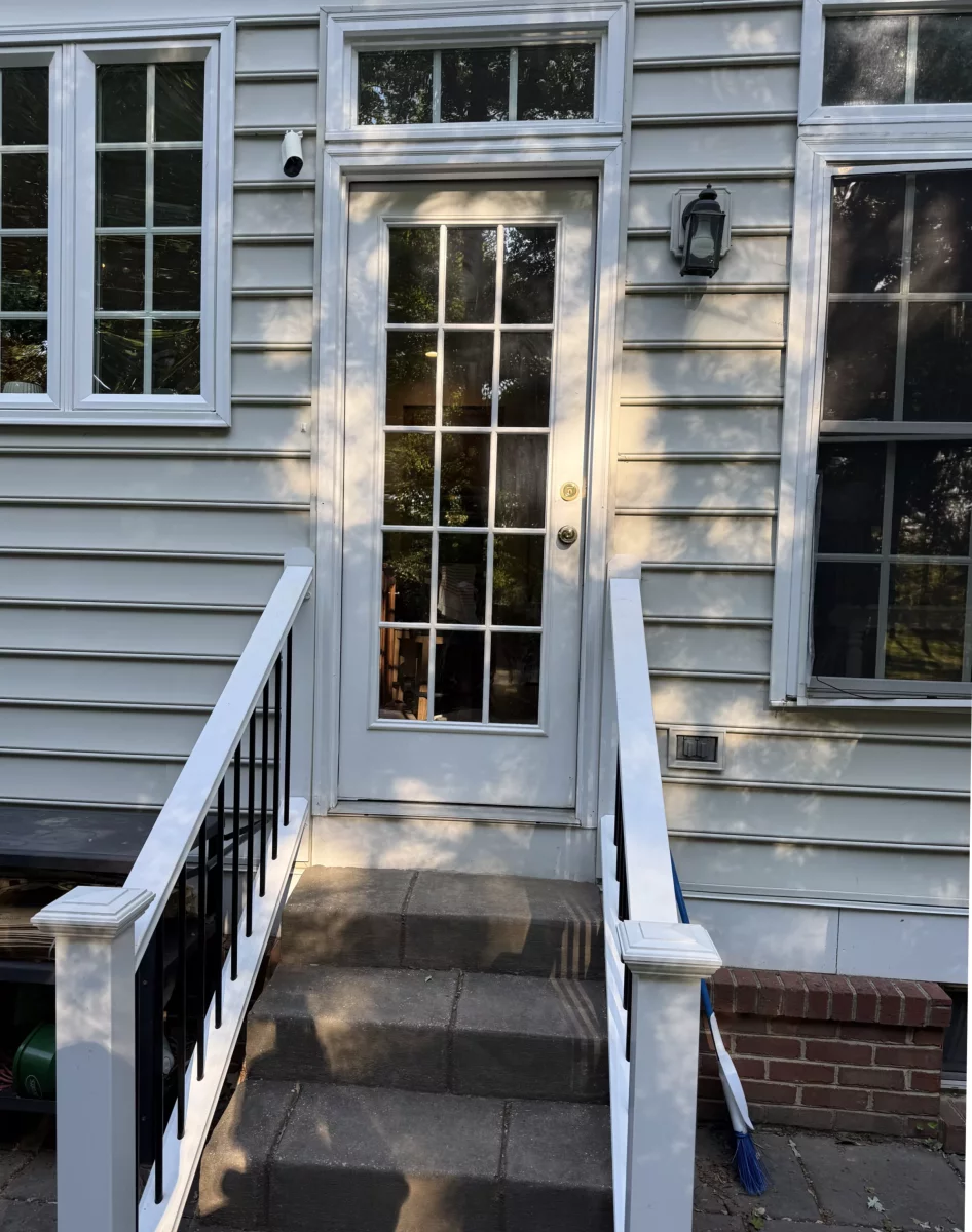 Exterior view of a residential door with glass panels and surrounding windows
