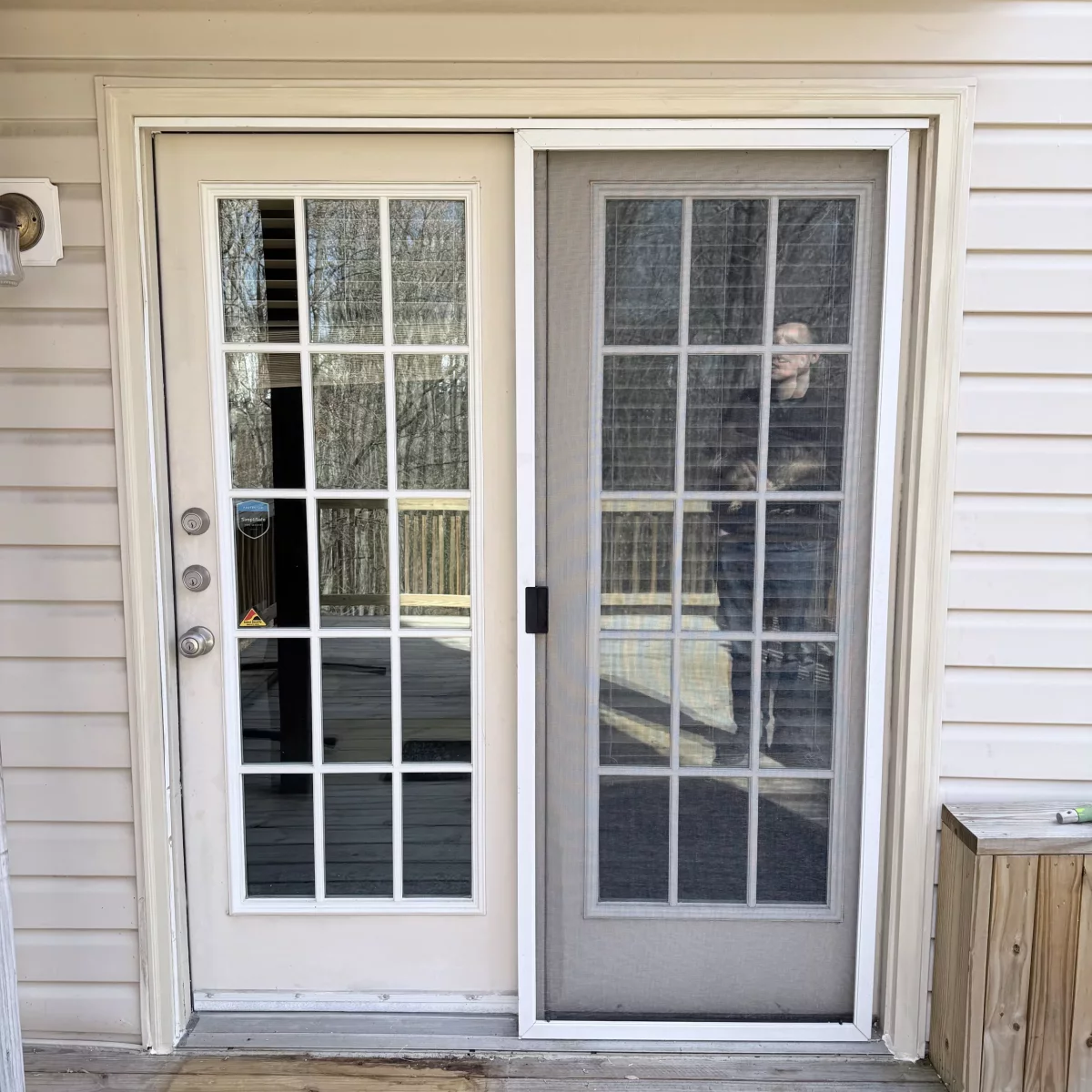 Exterior view of a patio door with screen and wood deck