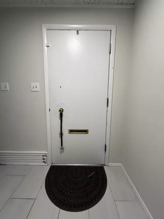 White interior door with mail slot and floor mat