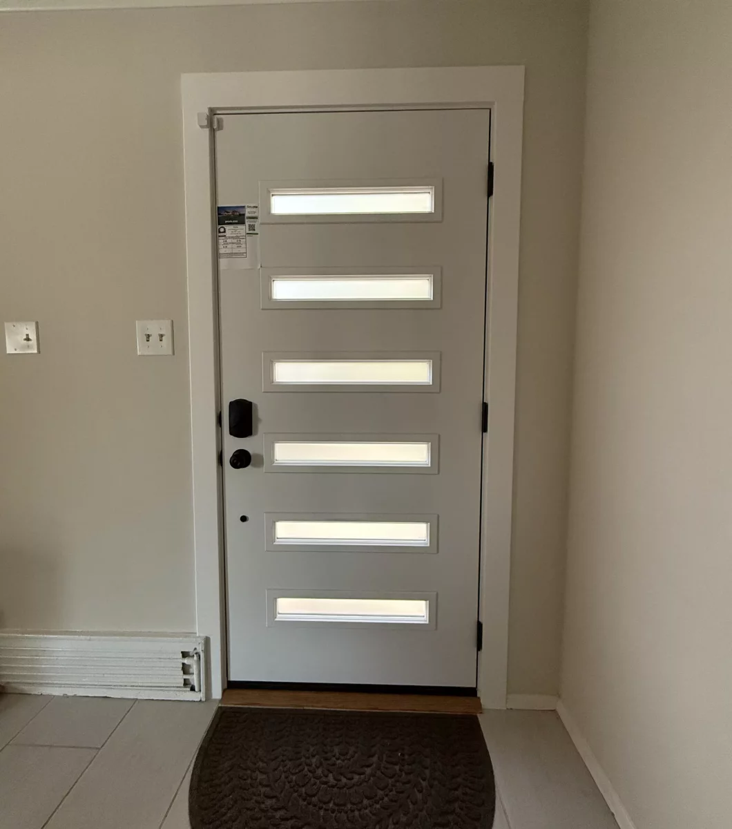 Modern entry door with horizontal glass panels in a residential interior