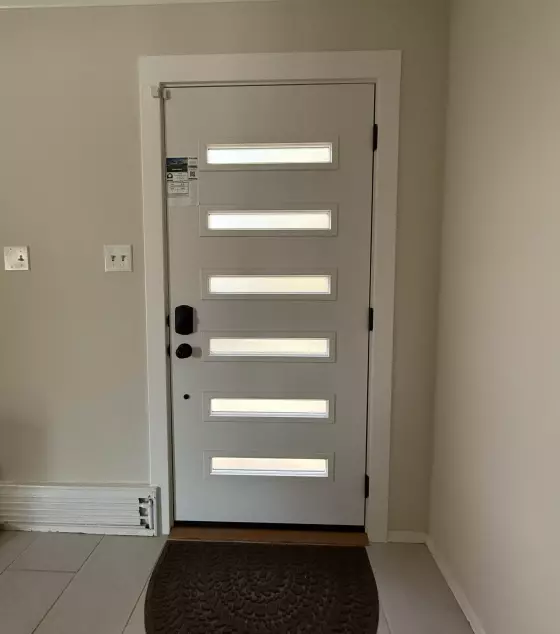 Modern entry door with horizontal glass panels in a residential interior