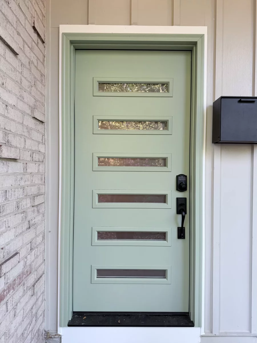 Green entry door with horizontal glass panels and black handle